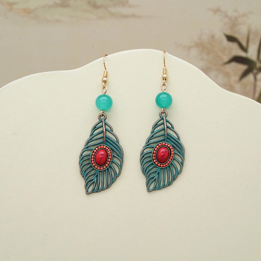 Blue enamel pendant earrings with fiery harmony design, close-up view.