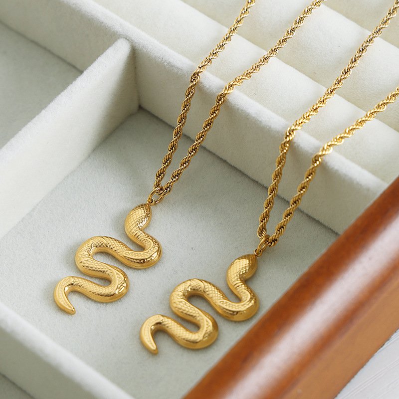 Blue Mystic Serpent pendant on a gold chain, close-up of intricate talisman charm.