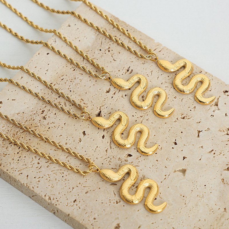 Blue Mystic Serpent pendant on a gold chain, close-up detail.