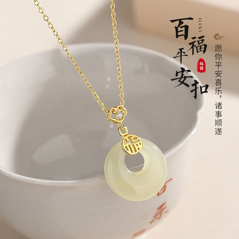 Celestial silver talisman pendant on a gold chain, offering serene protection.