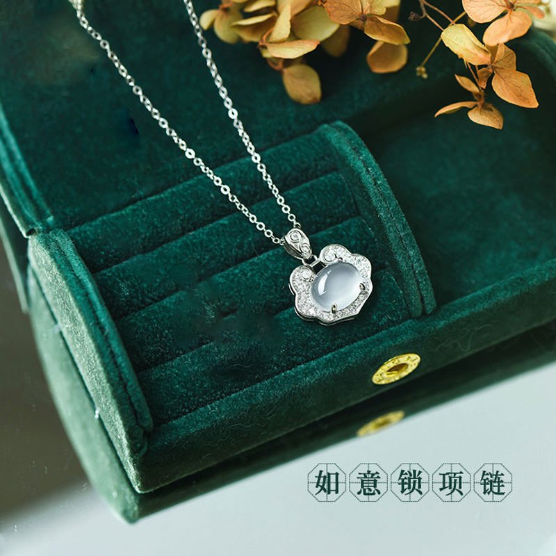 Celestial silver talisman pendant on a gold chain, close-up of charm.