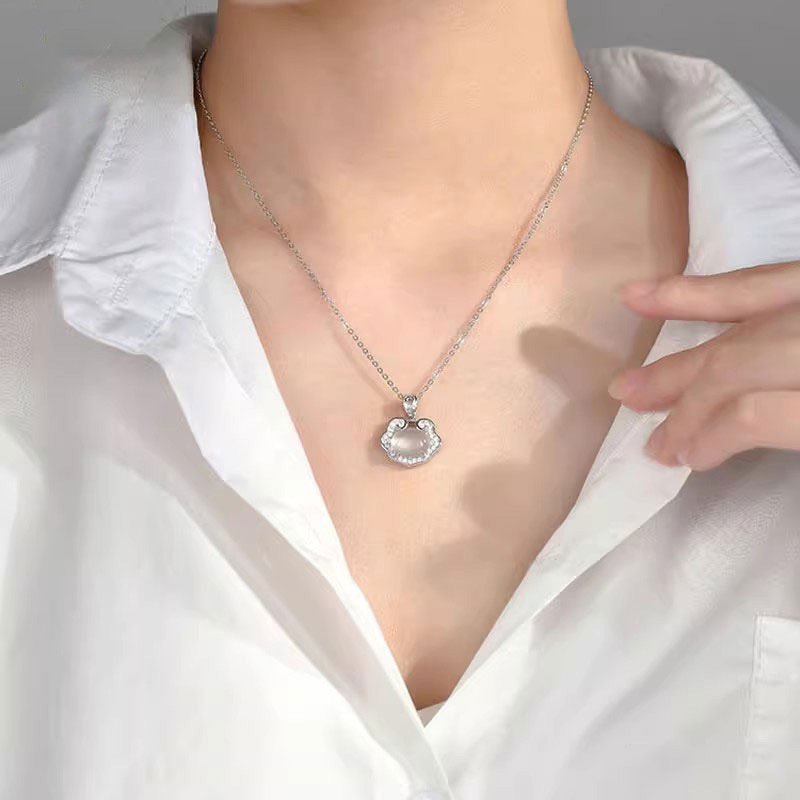 Silver celestial talisman pendant on a gold chain.