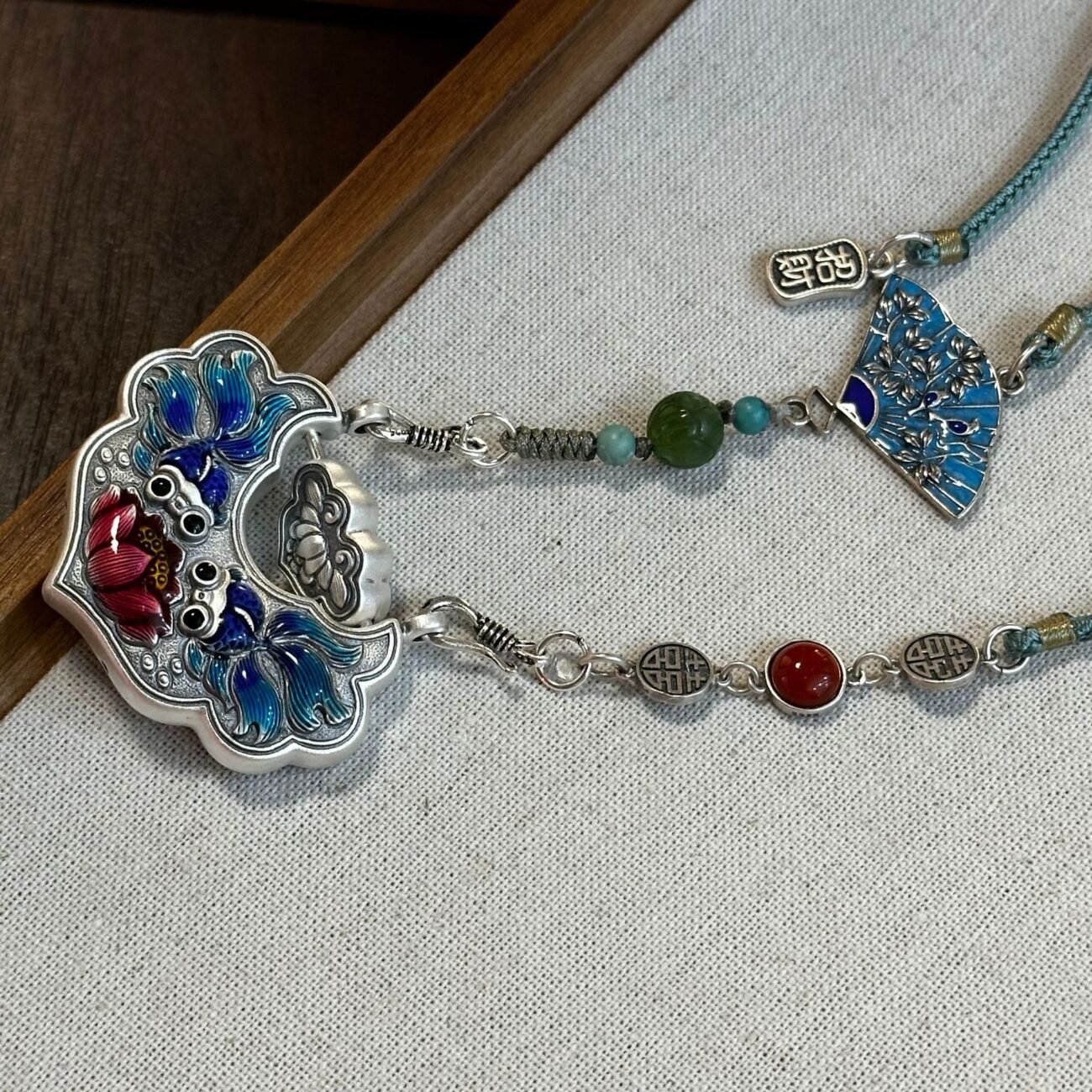 Silver scale necklace with artisan metalwork, symbolizing balance and fortune.