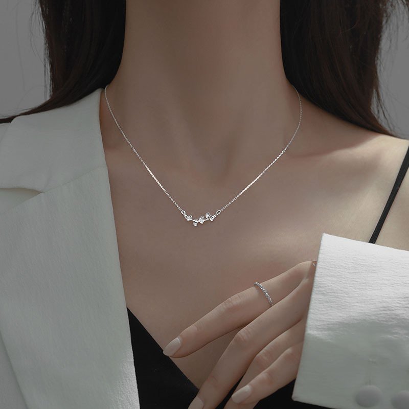 Silver leaf charm necklace with flowing metal design for balance and fortune.