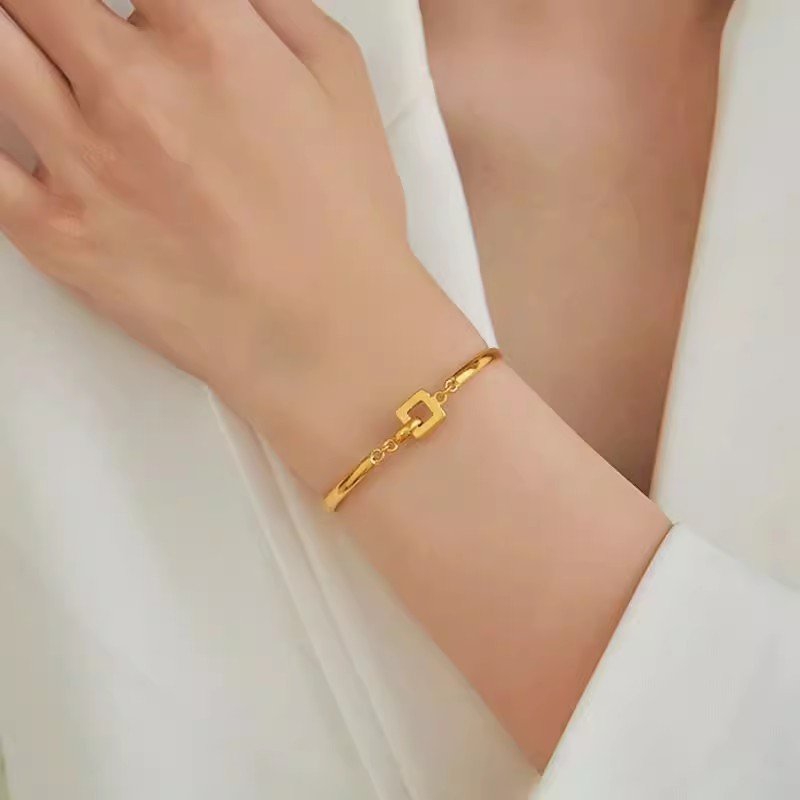 Aureum Harmony 14k gold bangle bracelet with lucky charm for fortune.
