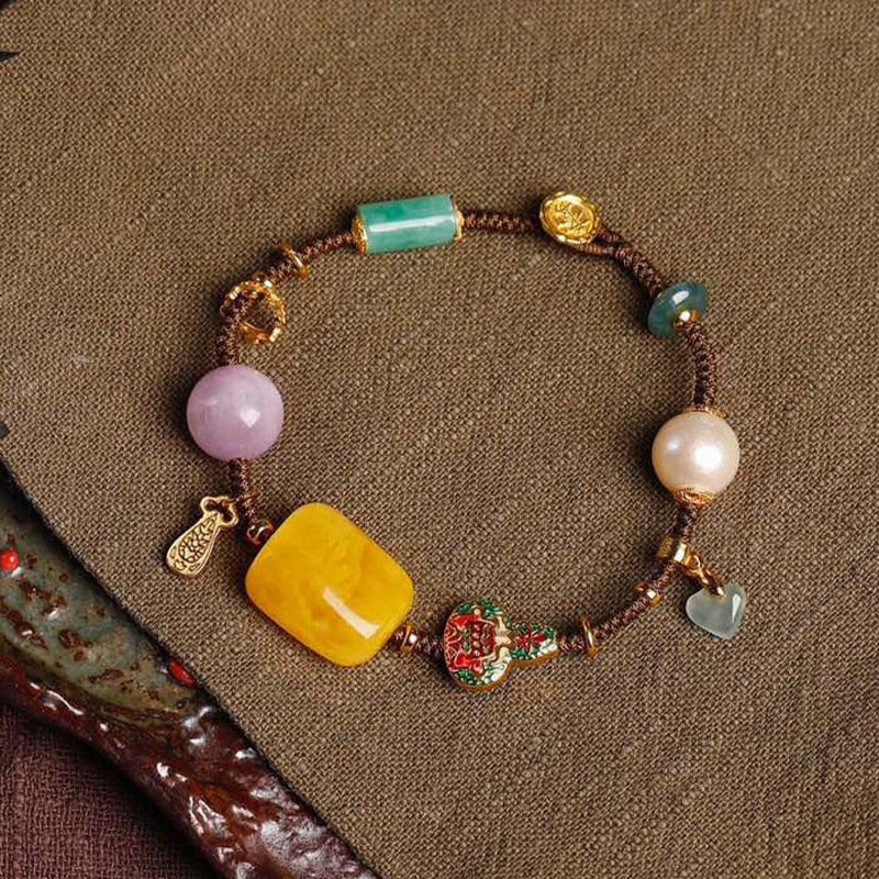 Gold celestial charm bracelet with intricate artisan metal details.
