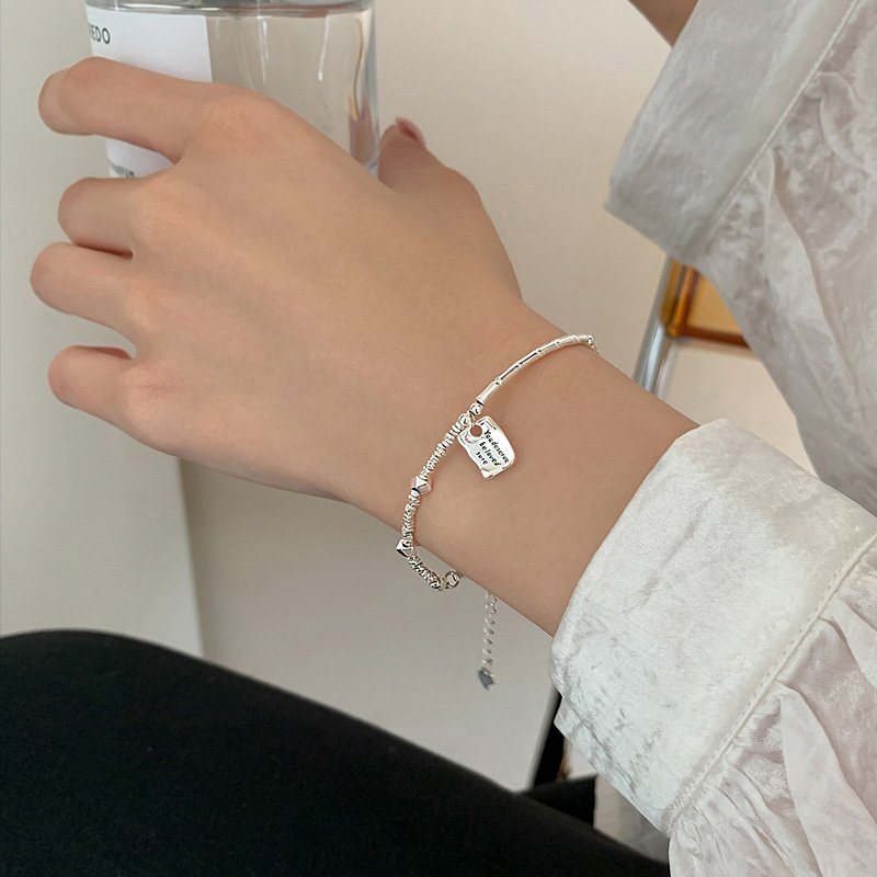Silver bamboo charm on kabbalah red string bracelet for fortune.