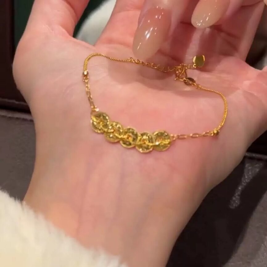 Golden Scale Ascendant Amulet bracelet with blue charm, a gold bangle for fortune.