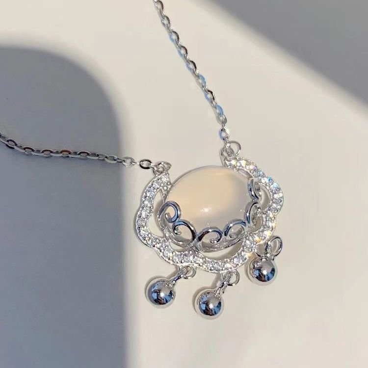 Celestial silver locket necklace with intricate charm, evoking timeless serenity.