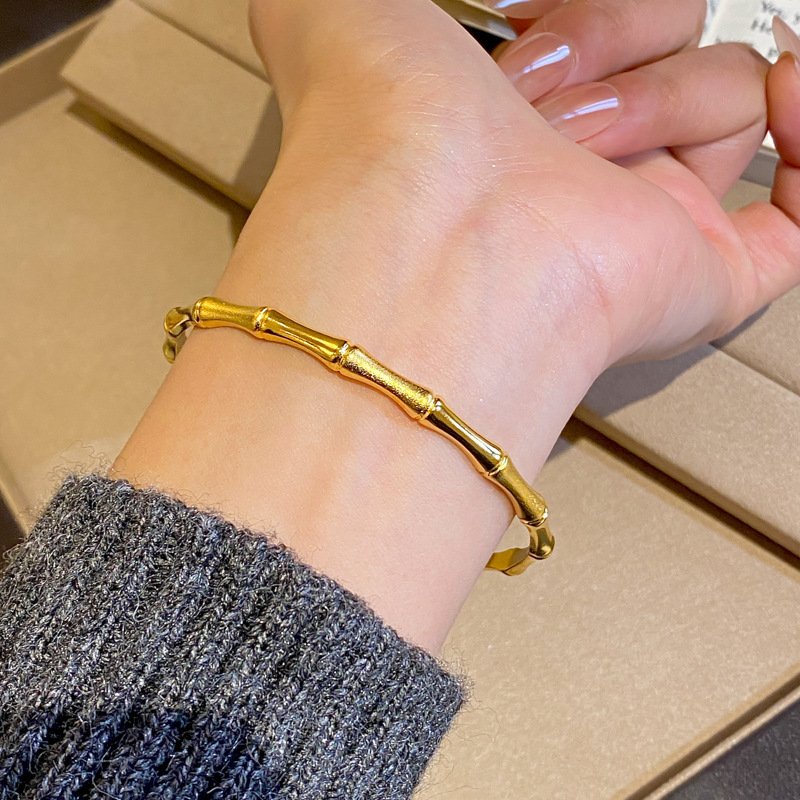 Golden Celestial Aurum Cuff bracelet with prosperity charm, close-up.