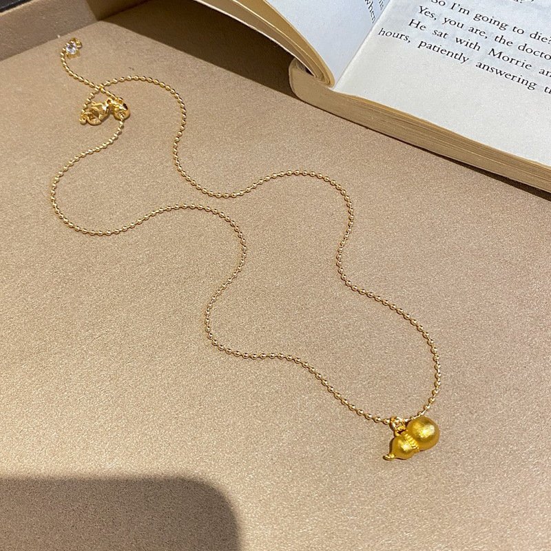 Golden Blossom Alchemy Elixir necklace with radiant charm, blue variant.