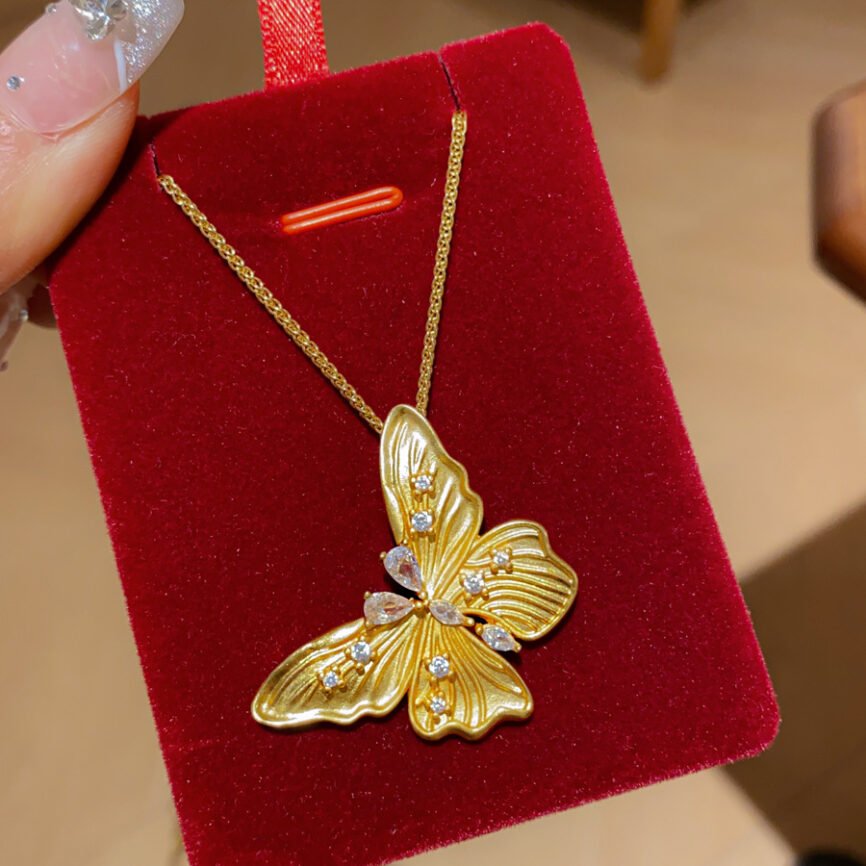 Golden Chrysalis Talisman necklace with metallic charm, close-up view.