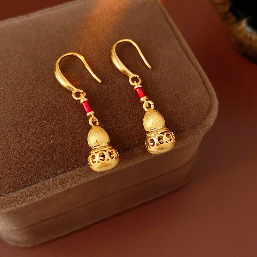 Blue Auric Flow gourd pendant earrings for women, close-up of metal charm.