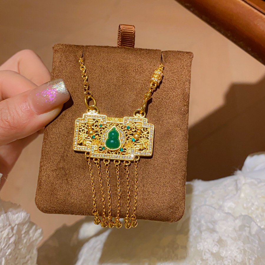 Blue jade pendant necklace with gilded talisman chain for harmony.