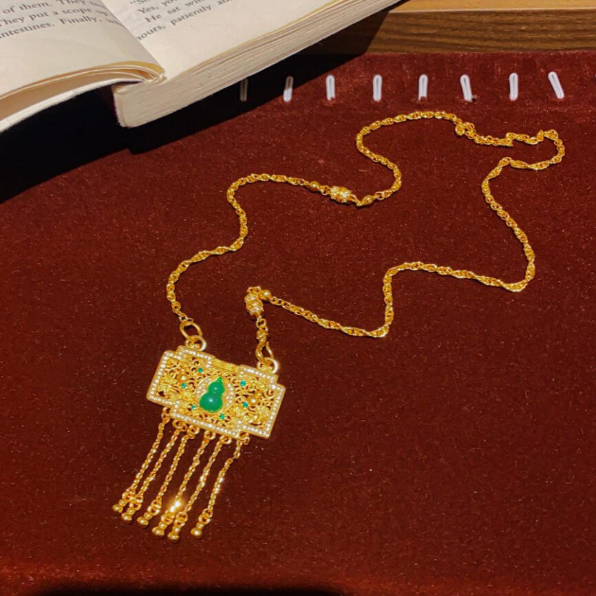 Blue jade pendant necklace with gilded talisman chain for harmony.