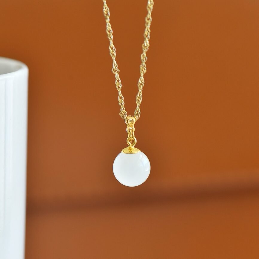 Silver locket with Chinese Hetian jade charm, artisan jewelry close-up.