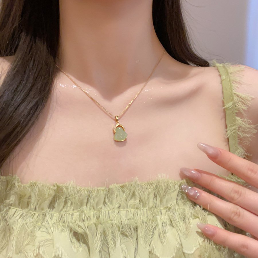 Blue Aureum Nexus pendant on a gold chain, close-up of intricate metal charm.