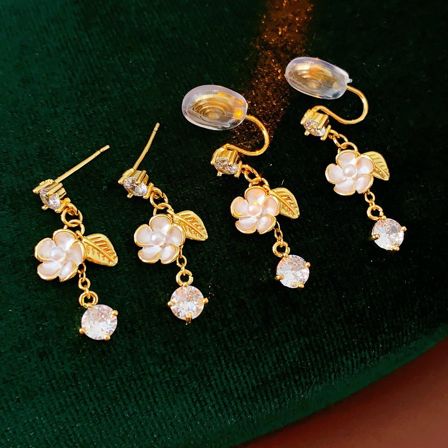 Blue jade earrings with gold accents and luminous pearl details.