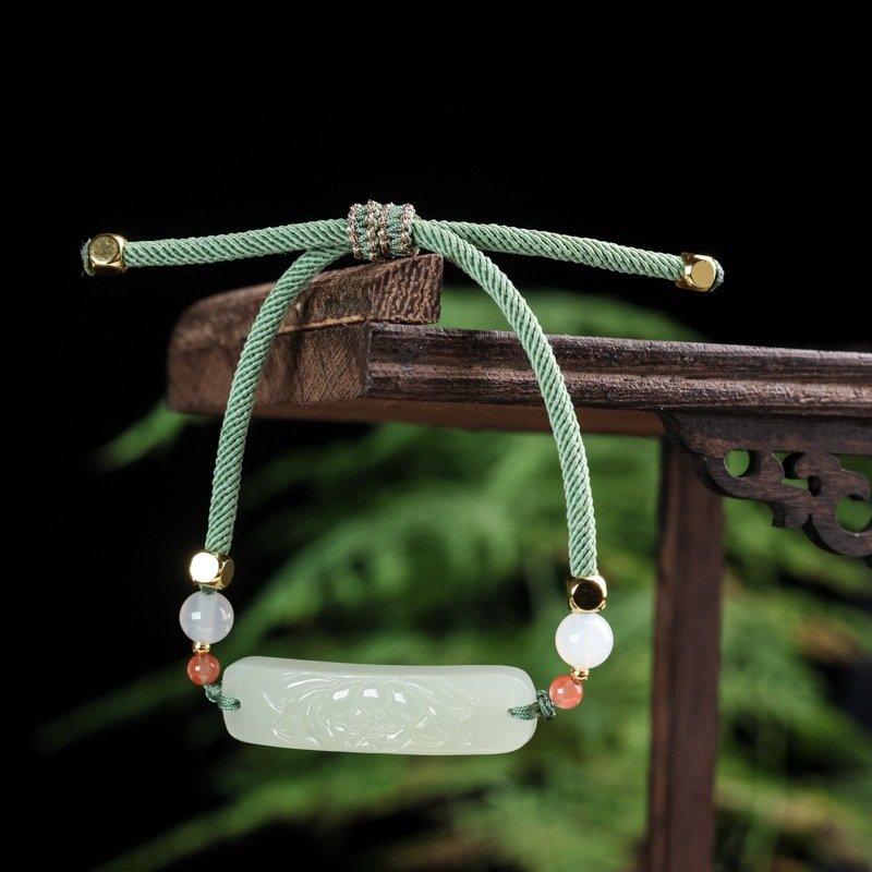 Blue Xinjiang Hetian jade bamboo charm pendant on artisan jewelry.
