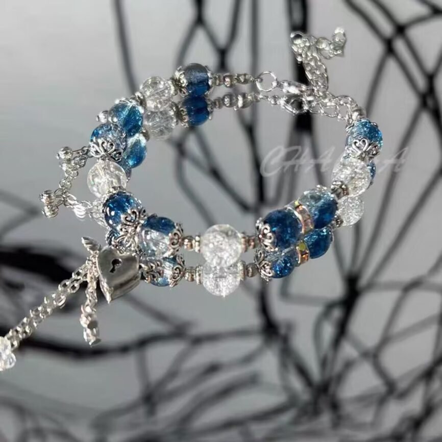 Blue celestial pearl bangle bracelet with cosmic charm close-up