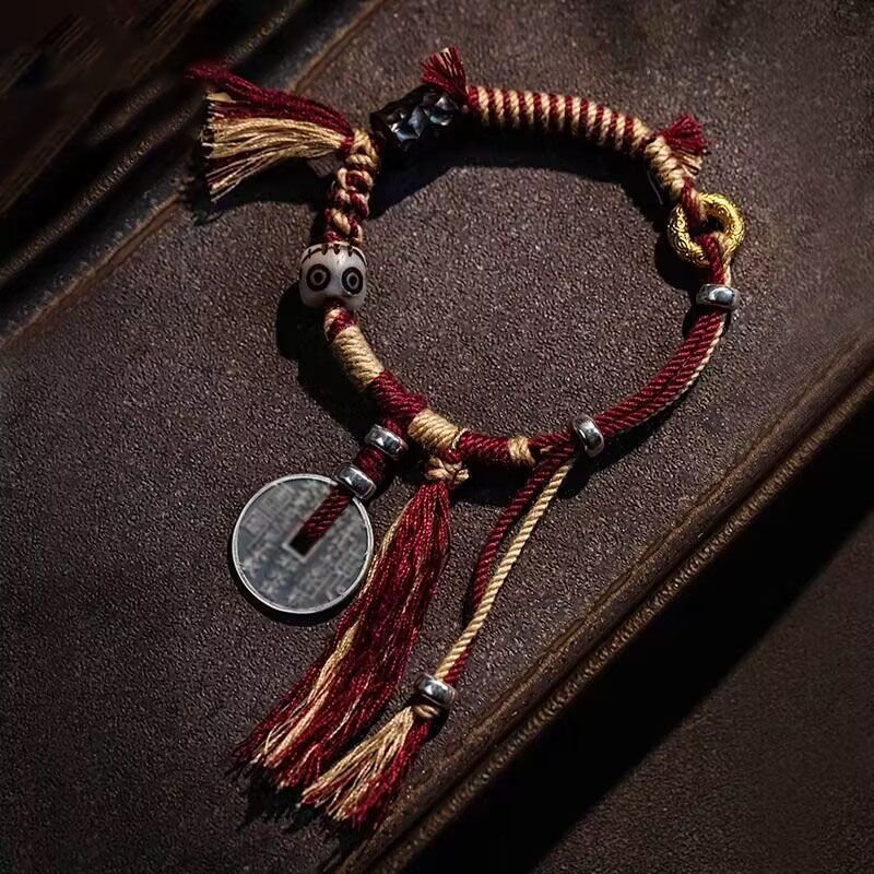 Red kabbalah string bracelet with intricate charm for protection and harmony.