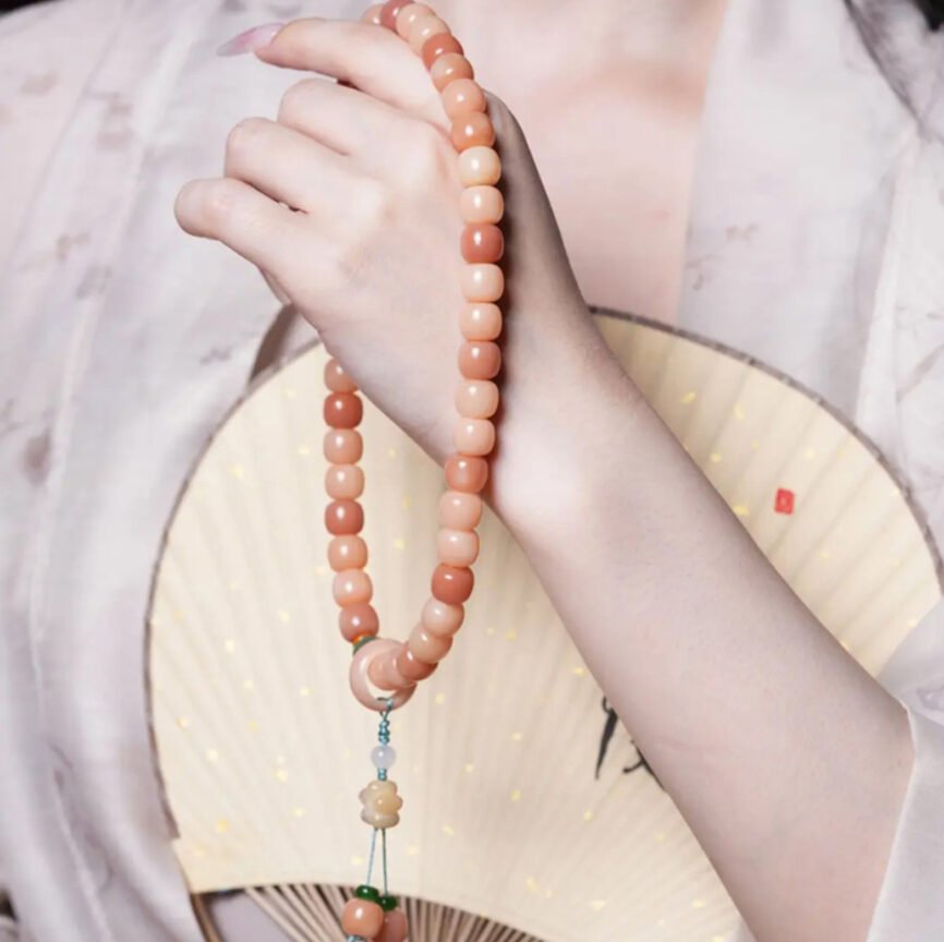 Eternal Bliss Peachwood Mala with charm, artisan jewelry for wealth and harmony.
